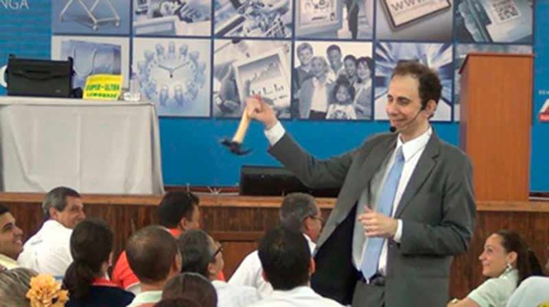 Palestrante Daniel Bizon fazendo humor com um martelo na mão Palestrante Daniel Bizon fazendo humor com um martelo na mão