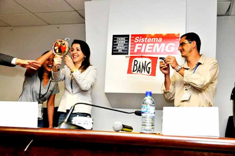 Três convidados no palco realizando uma dinâmica Três convidados no palco realizando uma dinâmica