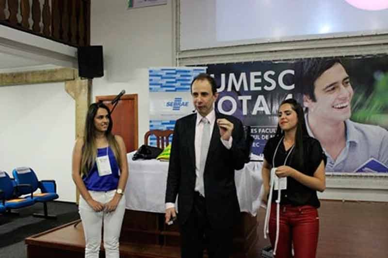Palestrante Daniel Bizon interagindo com convidadas no palco Palestrante Daniel Bizon interagindo com convidadas no palco